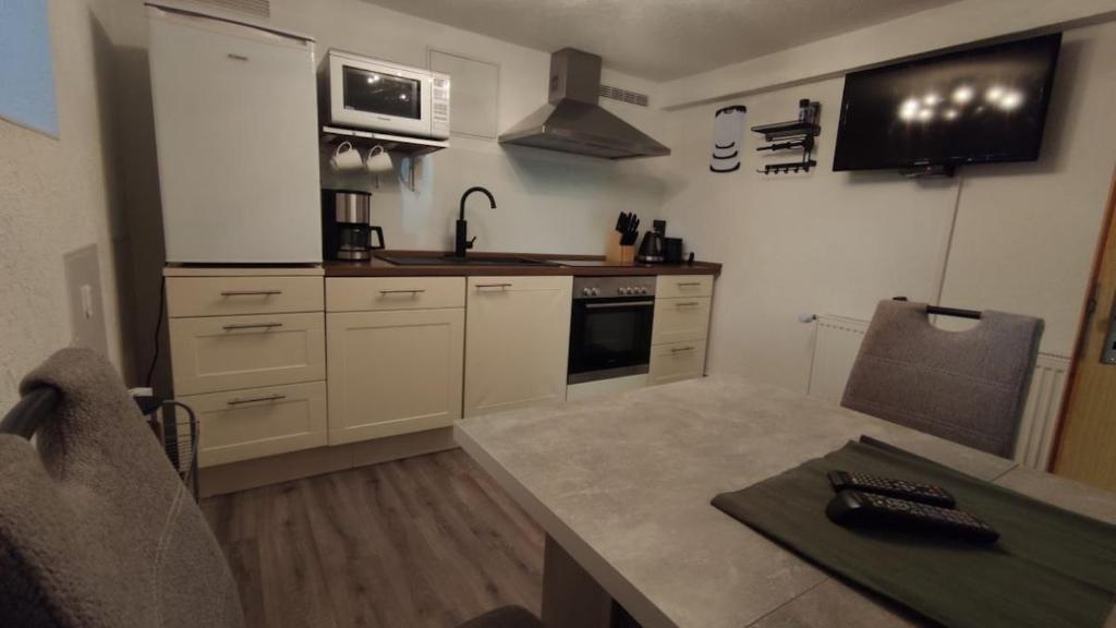 una cucina con mobili bianchi e un piano di lavoro di Ferienwohnung, Apartment, Pension - Berlin Neuenhagen a Niederheide