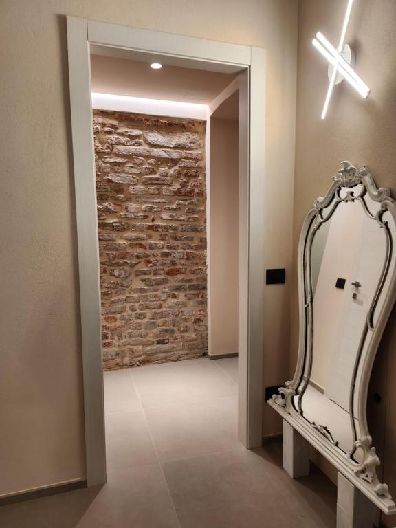 a mirror in a hallway with a brick wall at CA' 'D Ricardo in Alba