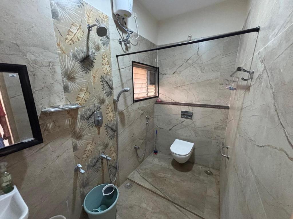 a bathroom with a shower and a toilet at Jeyaraj's Guest House in Samayanallūr