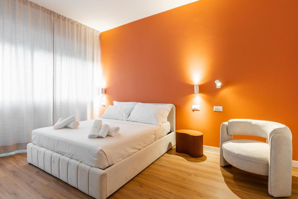 a bedroom with a white bed and a chair at Carducci Collection in Bologna