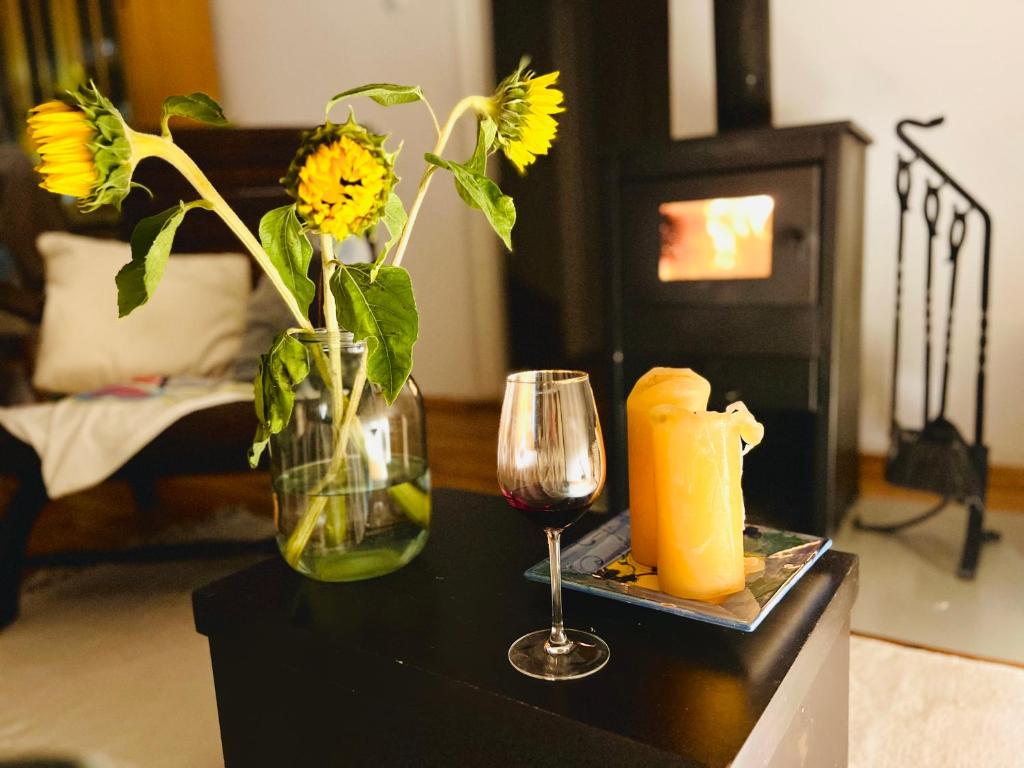 een tafel met een vaas met bloemen en een glas wijn bij Dom Verte z ogrodem na Jurze 