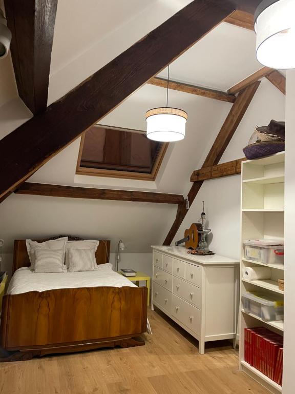 a bedroom with a bed and a dresser in a attic at belle chambre moderne , avec douche équippement complet in Nogent-sur-Marne