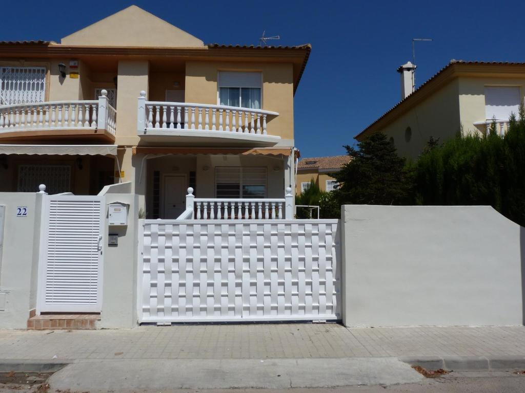 una recinzione bianca di fronte a una casa di Adosado Calle Mar Cantabrico a La Pobla de Vallbona