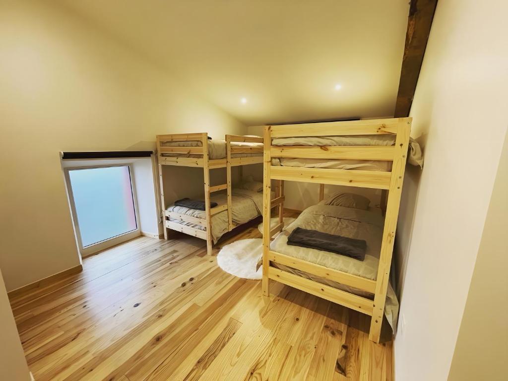 Un dormitorio con literas en una habitación con suelo de madera. en Gite Goitiaya, en Luxe-Sumberraute
