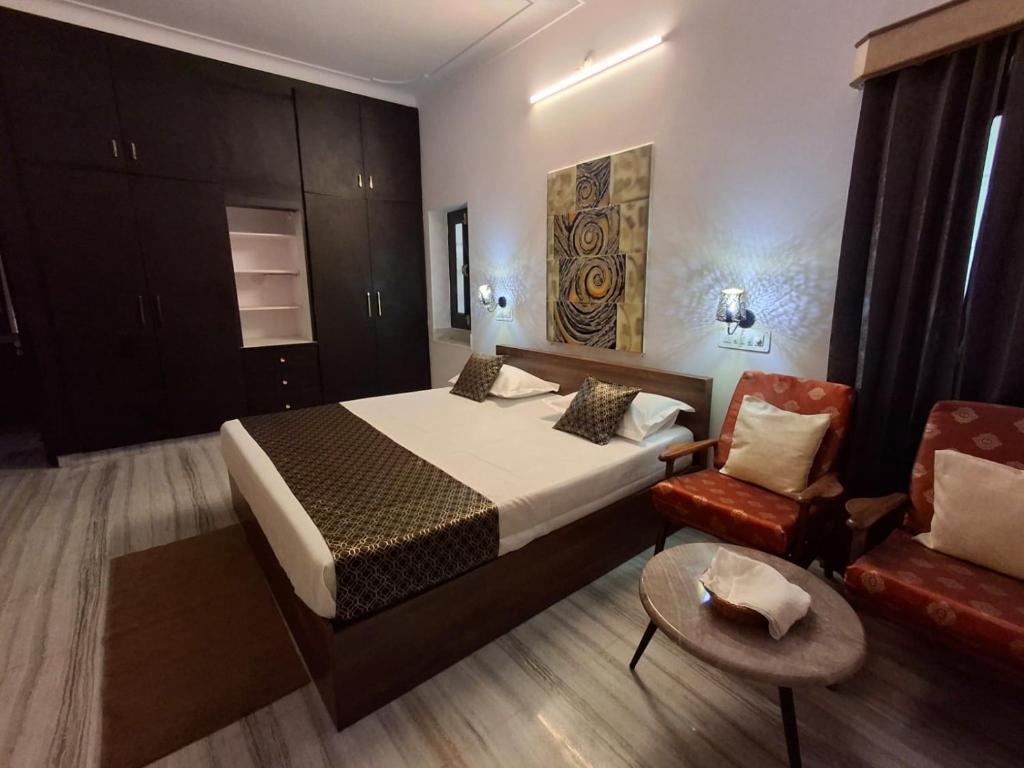 una habitación de hotel con una cama y una silla en The Ramayana, en Udaipur