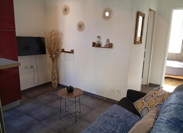 a living room with a couch and a table at Aux portes de l'Eure in Bonnières-sur-Seine