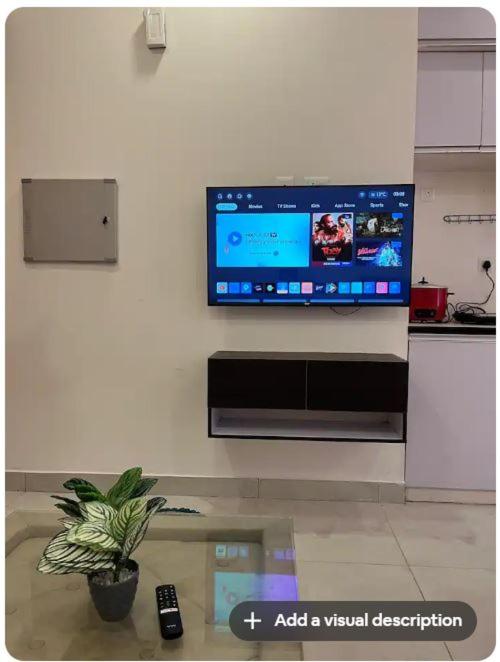 a tv on a wall in a living room at Hello Studio in Noida