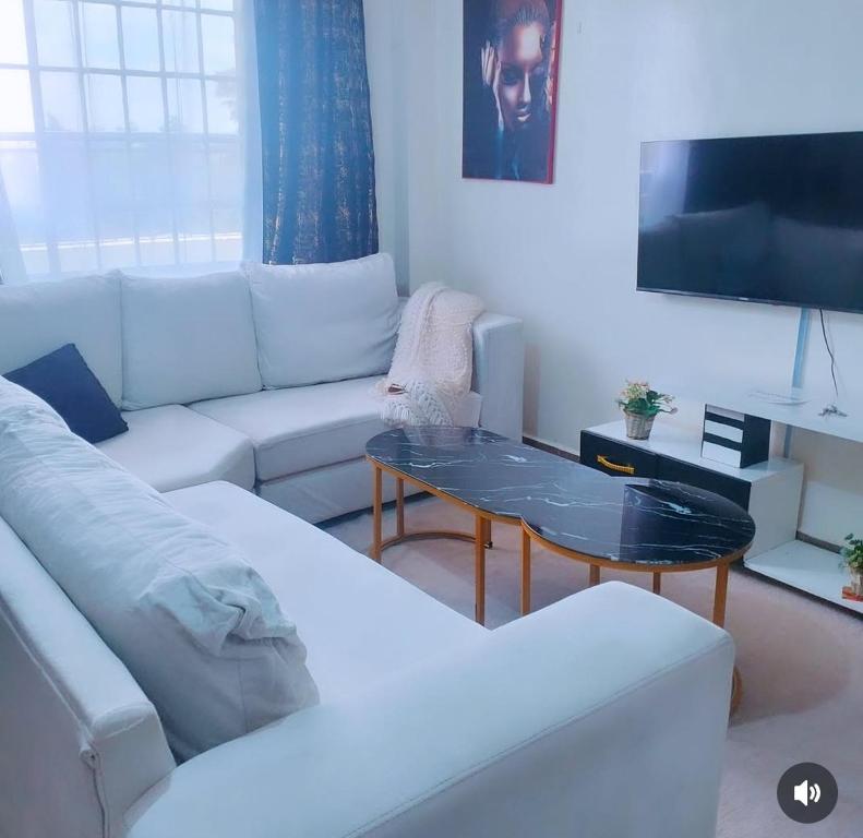 a living room with a white couch and a table at Lynn in Nanyuki