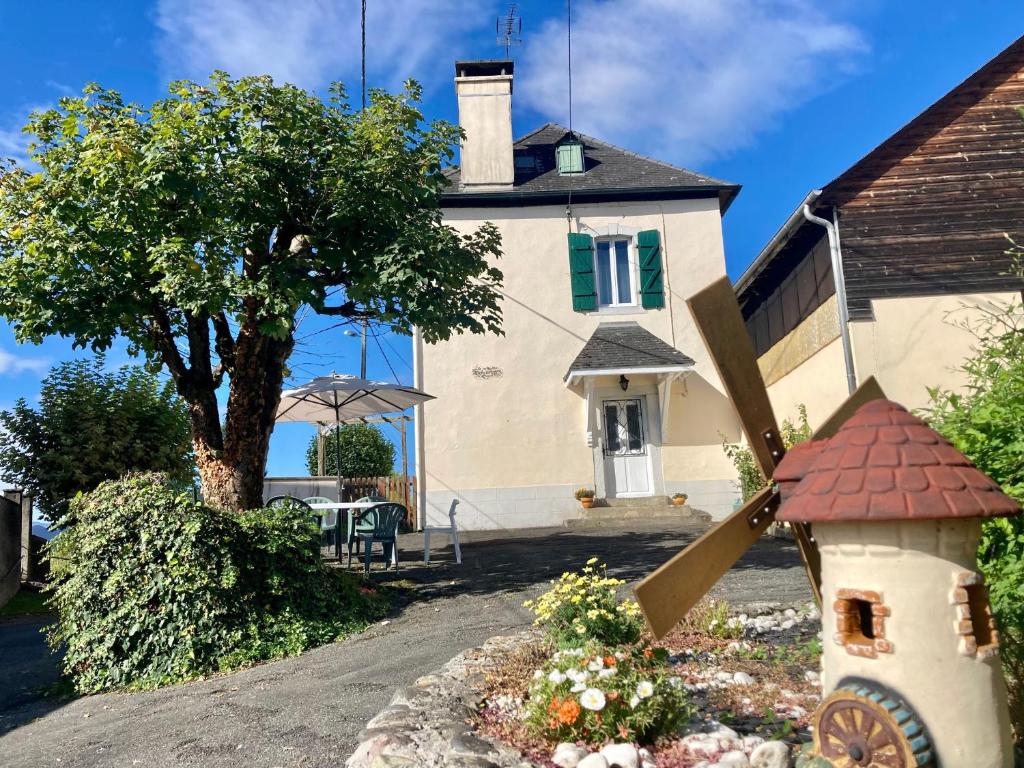a house with a large windmill in front of it at La Maison Marguerite in Herrère