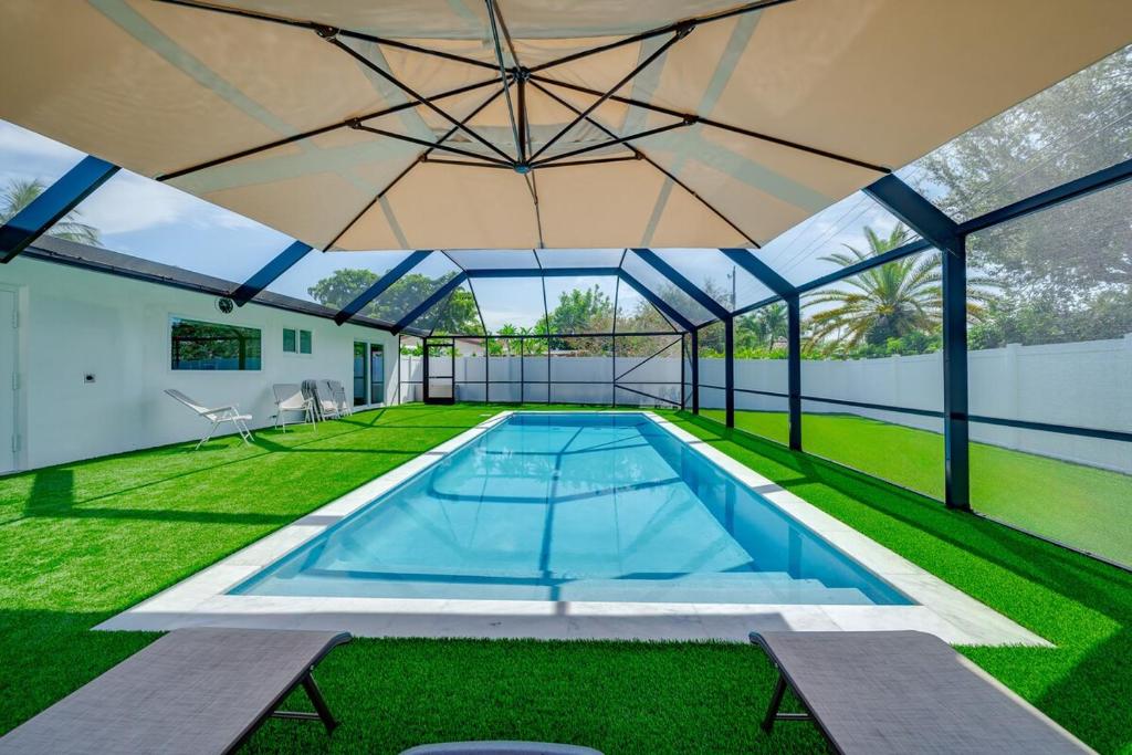 a swimming pool in a house with a large roof at Modern House Close to the Beach in Deerfield Beach