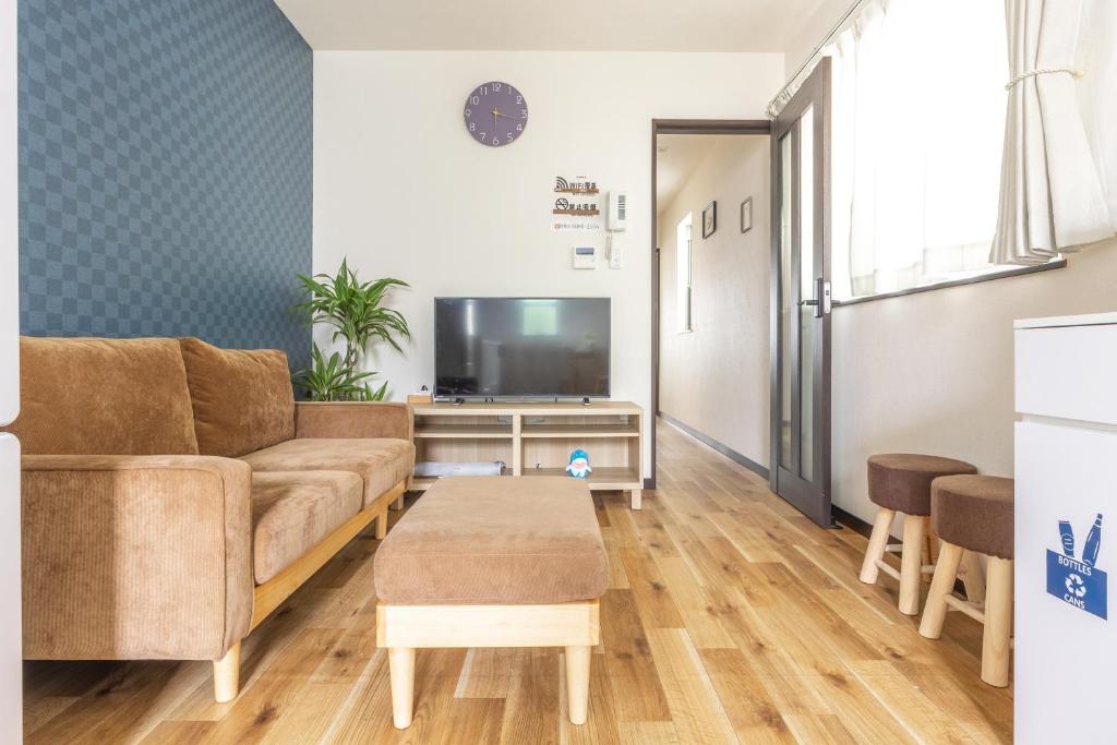 a living room with a couch and a tv at Nogata Station 3 minutes on foot , 15 minutes to Shinjuku in Tokyo