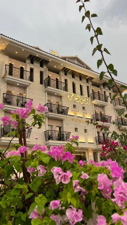 a building with pink flowers in front of it at Rox Luxury Hotel - روكس الفاخرة in Taif