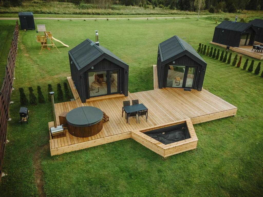 une vue aérienne d'une maison avec une terrasse et une table dans l'établissement Rātes Krasti - PĒRLE- holiday house with sauna and lakeview, à Lejasciems