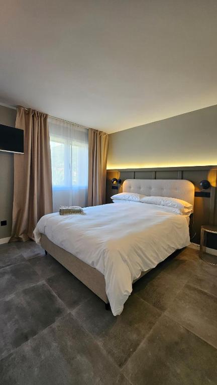 a large white bed in a bedroom with a window at Casa Candeleda Alojamiento Boutique in Candeleda