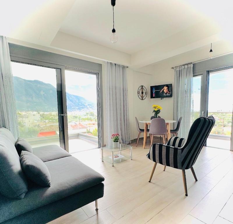 a living room with a couch and a table with chairs at Comfy Vista Apartment in Kalamata