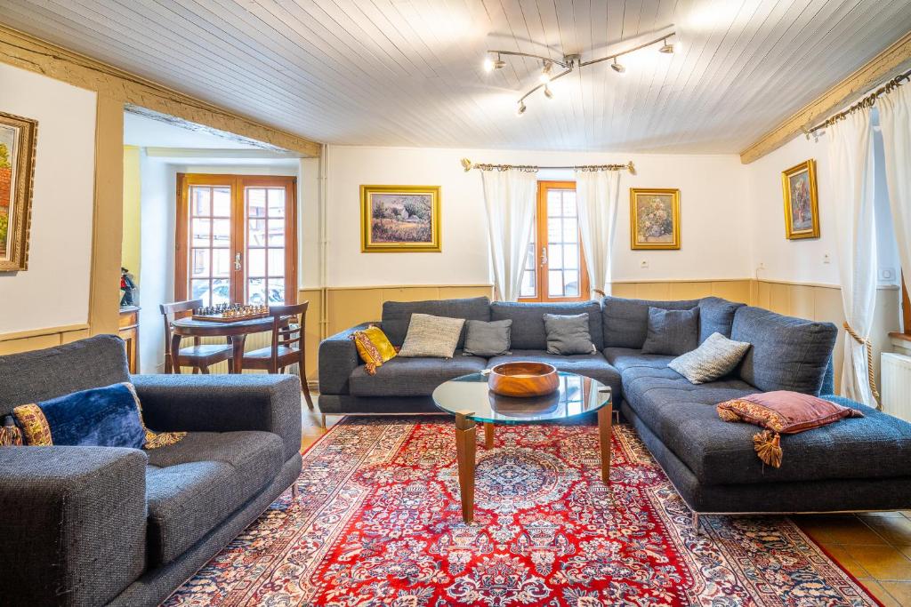 a living room with two couches and a table at Typical Alsace house - ideal for groups and families in Dambach-la-Ville