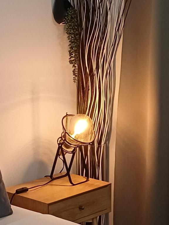 Una lámpara colocada en una mesita de noche junto a una planta. en Rafina's Blue Heart!Walking access to the PORT!!!Unique style!!Superior Quality!!!, en Rafina