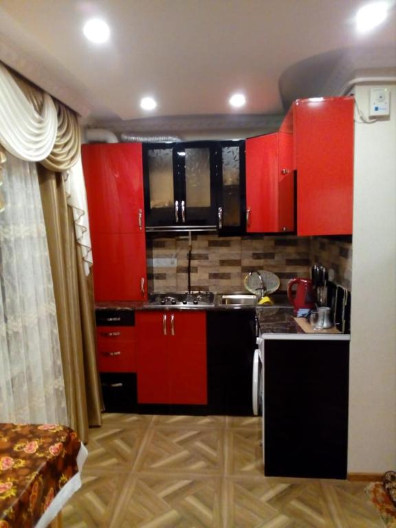 a small kitchen with red cabinets in a room at Джермук in Jermuk