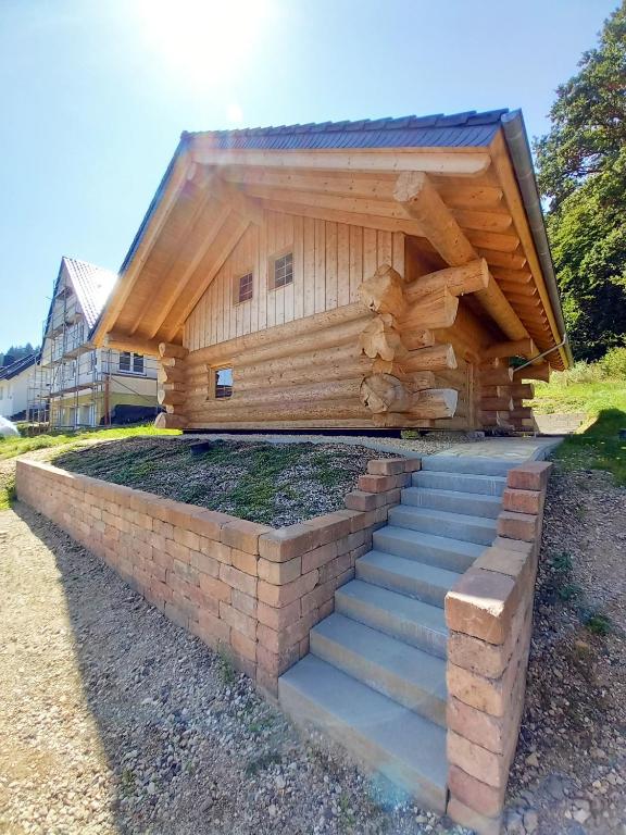 a log cabin with stairs in front of it at Ferienhaus Waldruhe in Hellenthal