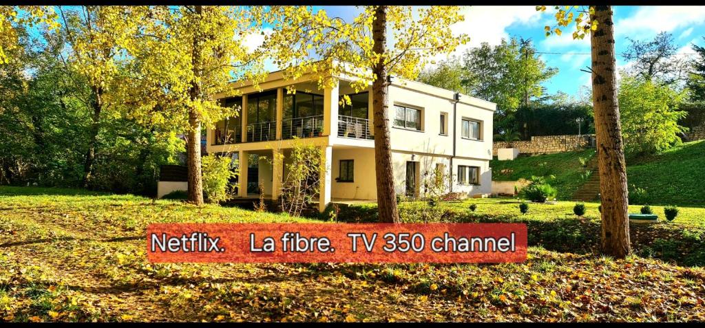 una grande casa bianca con un cartello davanti di T-2 ouest 47m2 la maison au bord du Canal du Midi a Sainte-Colombe-en-Bruilhois