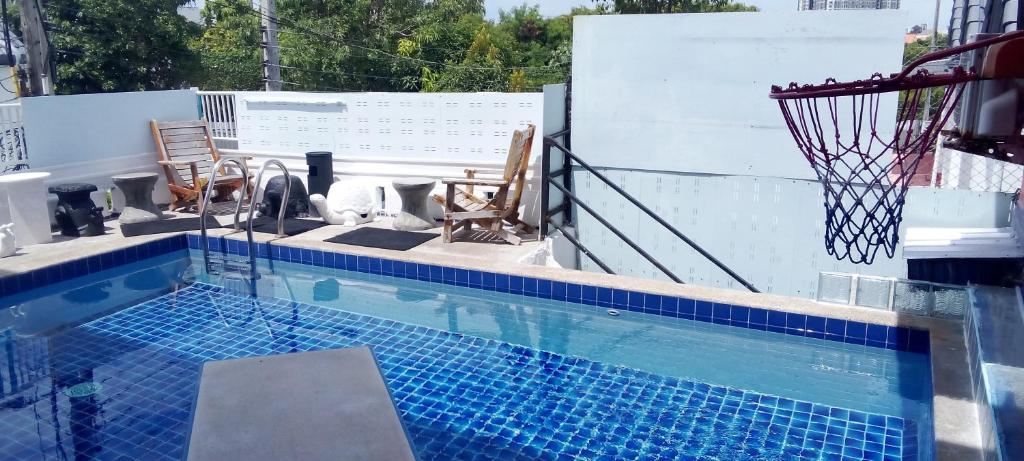 a swimming pool with a basketball hoop on a building at BEN & LEK GUESTHOUSE in Pattaya South