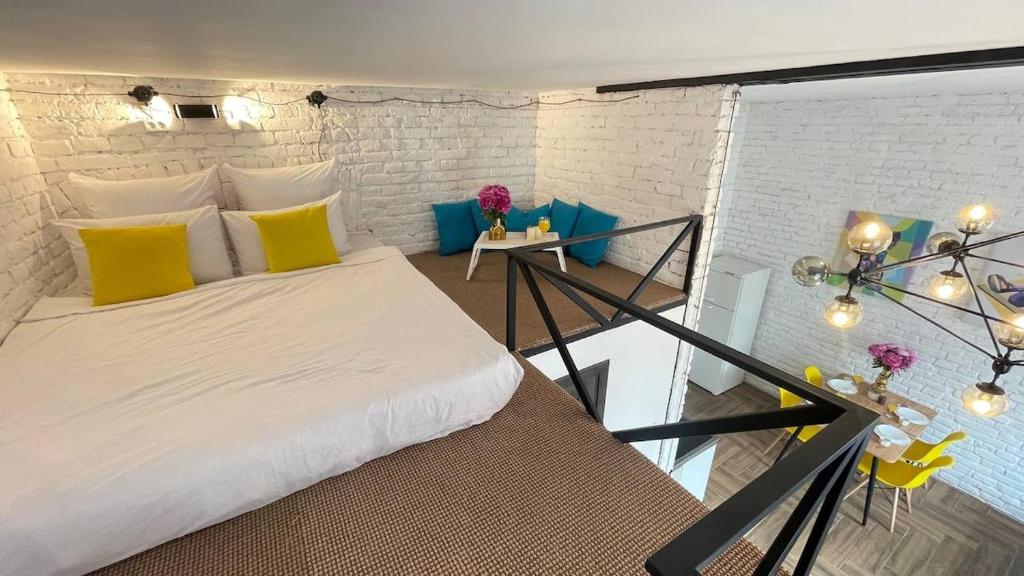 a bedroom with a bed with yellow and blue pillows at Квартира-студія в історичному центрі міста біля Центральної площі in Chernivtsi