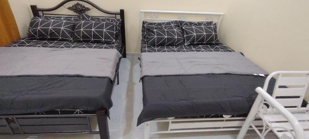 two bunk beds in a room with a chair at Roomstay Cheq Ayoh Pantai Penarik Setiu in Kampong Ru Sepuloh