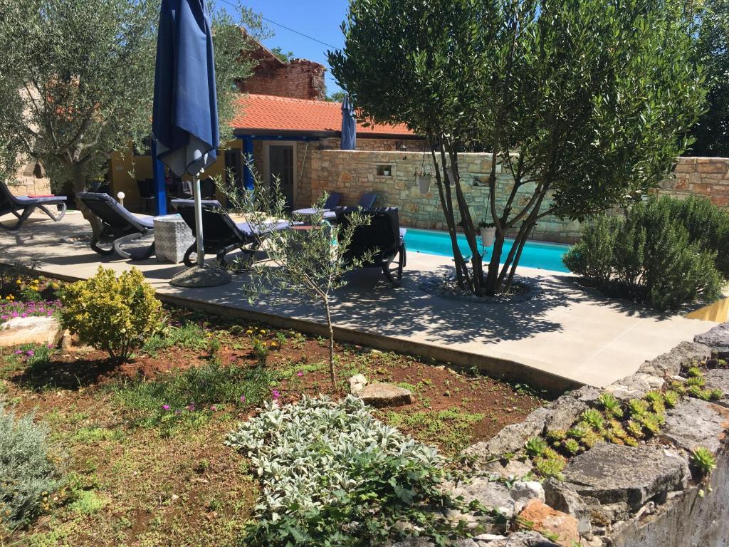 a garden with a pool in the background at Holiday Home Ava1 with pool & Holiday Home Ava2 with whirlpool in Baderna