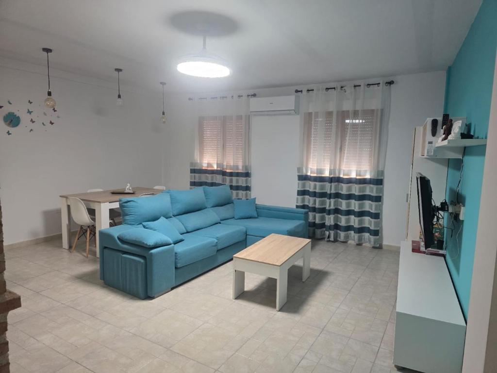 a living room with a blue couch and a table at Atardecer dorado in Ruidera