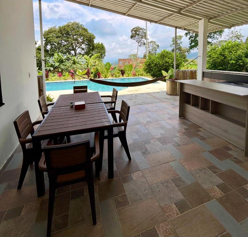 comedor con mesa, sillas y piscina en Casa Jaguar Viotá, en Viotá