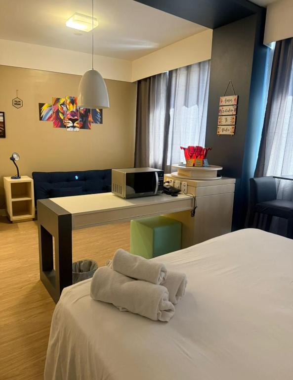 a hotel room with a bed with towels on it at Flat em Alphaville Hotel in Barueri