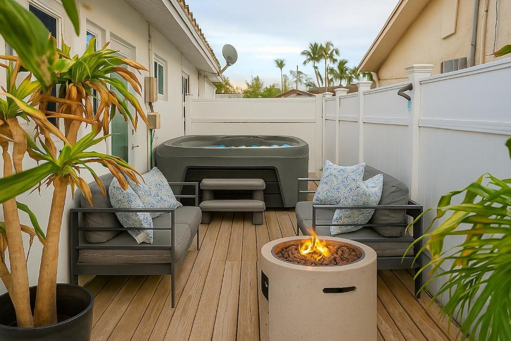 Un patio con jacuzzi, sillas y fogata. en Steps from Airport Hot Tub Bbq Boat Slip, en Dania Beach