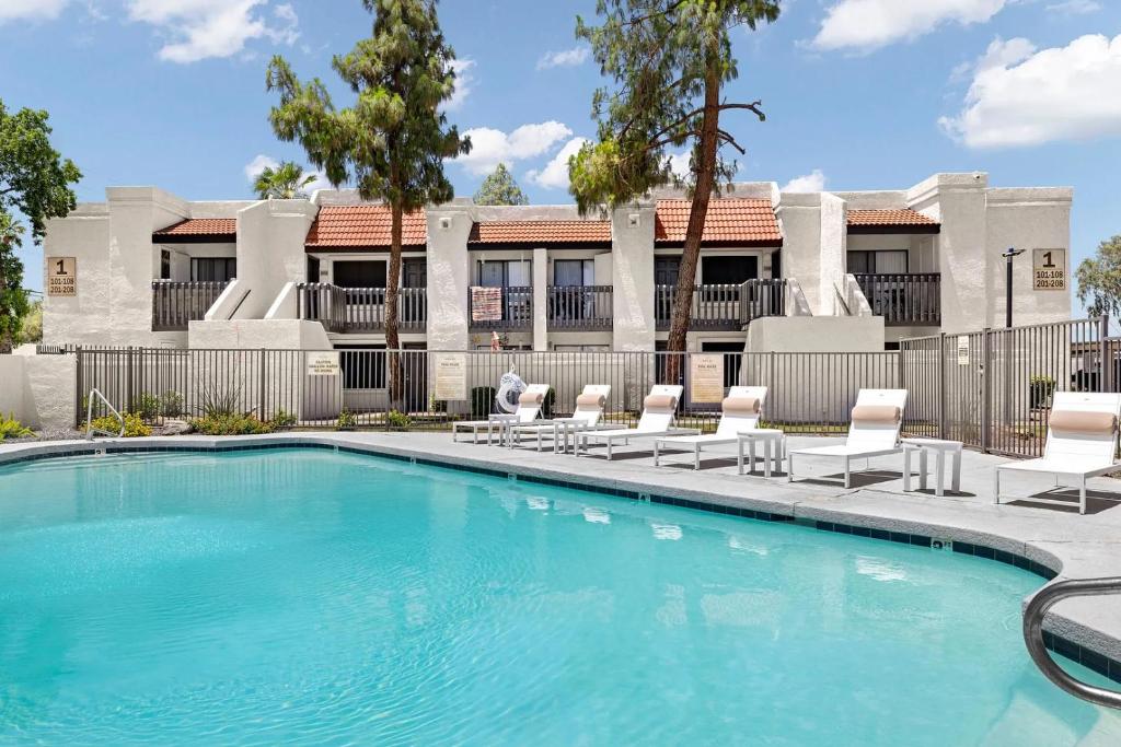 einen Pool mit Liegestühlen vor einem Gebäude in der Unterkunft Landing Apartments Phoenix - Maryvale Village in Phoenix