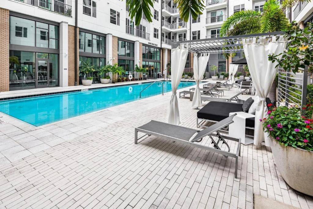 オーランドにあるLanding Apartments Orlando - Central Business Districtの建物の隣にスイミングプール(ハンモック付)