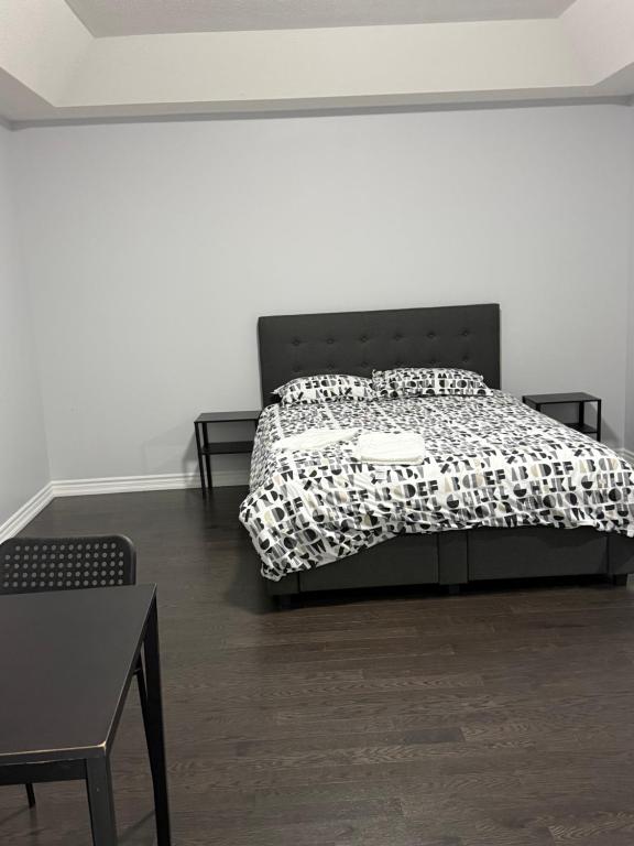 a bedroom with a bed with a black and white comforter at masters bet room in Whitby