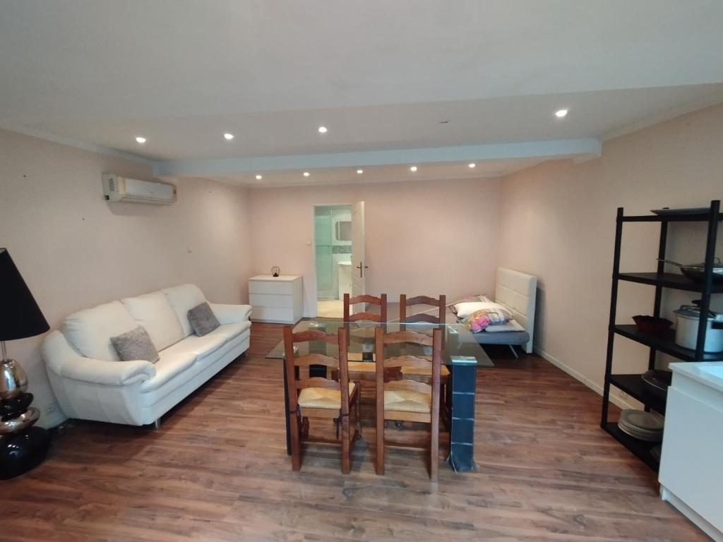 a living room with a table and chairs and a couch at Studio A côté Du Plus Beau Marché De France in Béziers