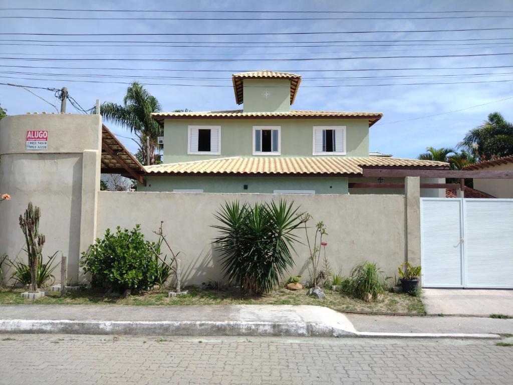 une maison blanche avec un toit jaune dans l'établissement Casa em Buzios, à Búzios