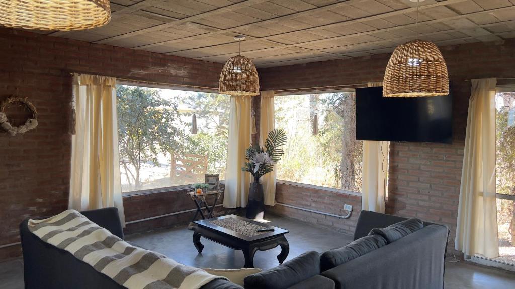 a living room with two couches and a table at La Casona Dique Chico in Villa Anizacate