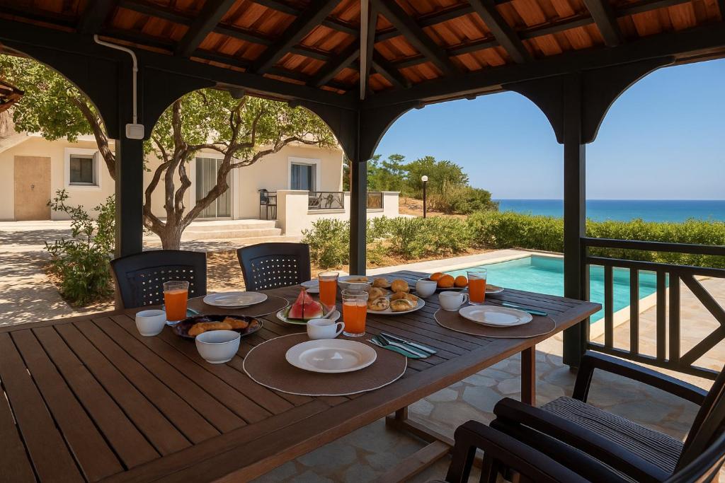 a wooden table with food on it on a patio at Villa Melenia for Family Holidays by the Beach in Agia Pelagia