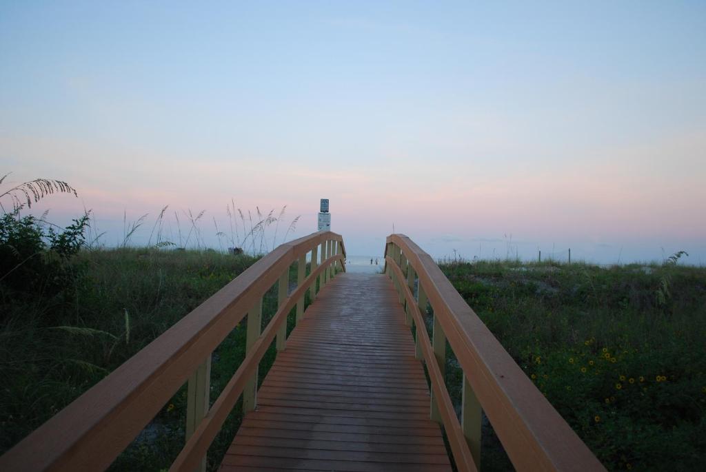 a wooden bridge leading to a lighthouse on the beach at Winter Sale on Now-Sunset Vistas 303N 100s 5 stars in St Pete Beach