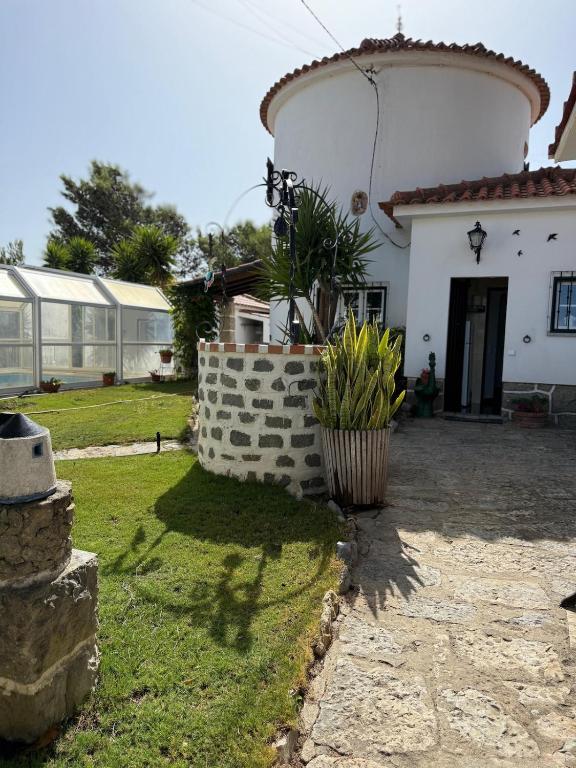 a white house with a brick wall in front of a yard at Moinho da Saudade in Alcabideche