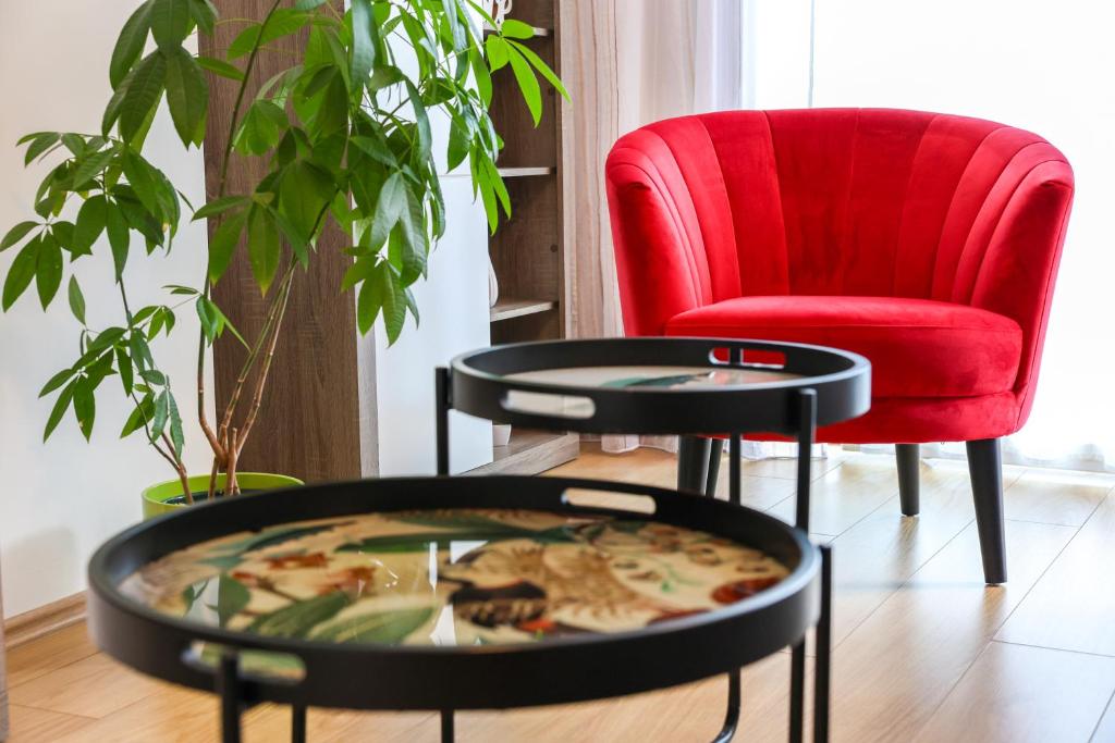 a living room with a red chair and a table at Apartment Piano in Rijeka