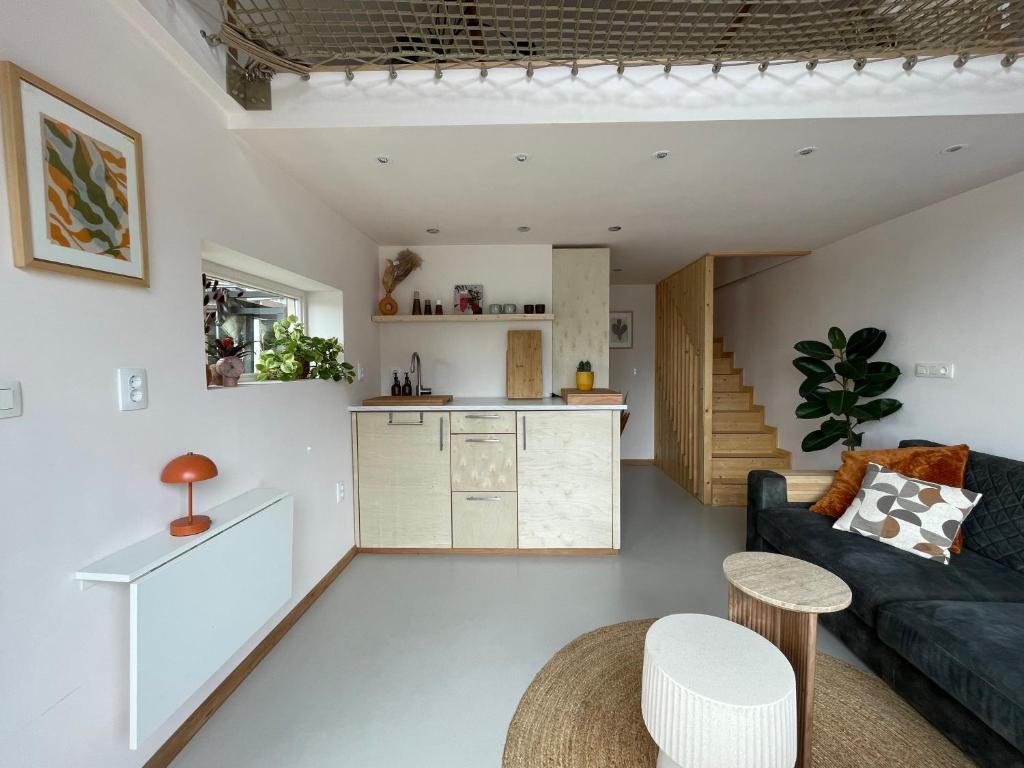 una sala de estar con un sofá y una mesa en Casa aan de vecht, en Ons Belang