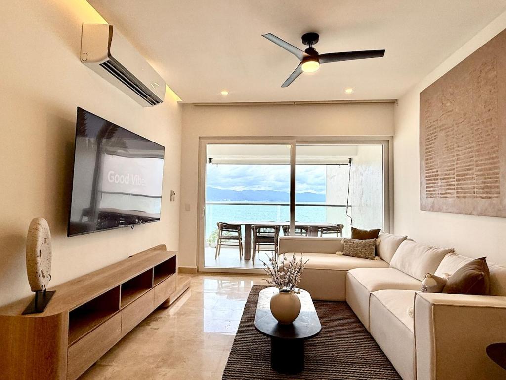 a living room with a couch and a flat screen tv at Harbor NT507 by Moikkarentals in Puerto Vallarta