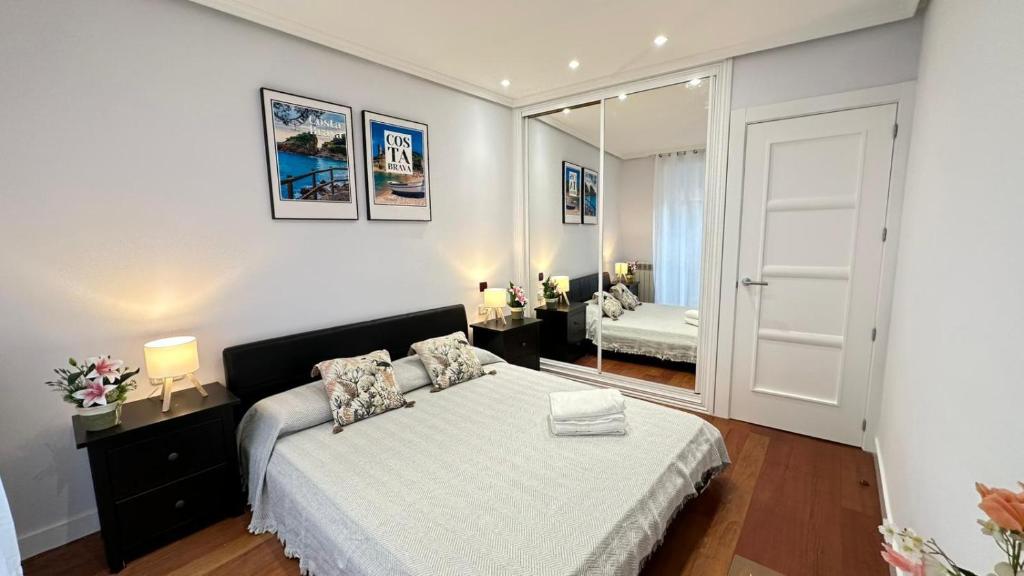 ein Schlafzimmer mit einem großen Bett und einem Spiegel in der Unterkunft Habitaciones en Toledo in Madrid