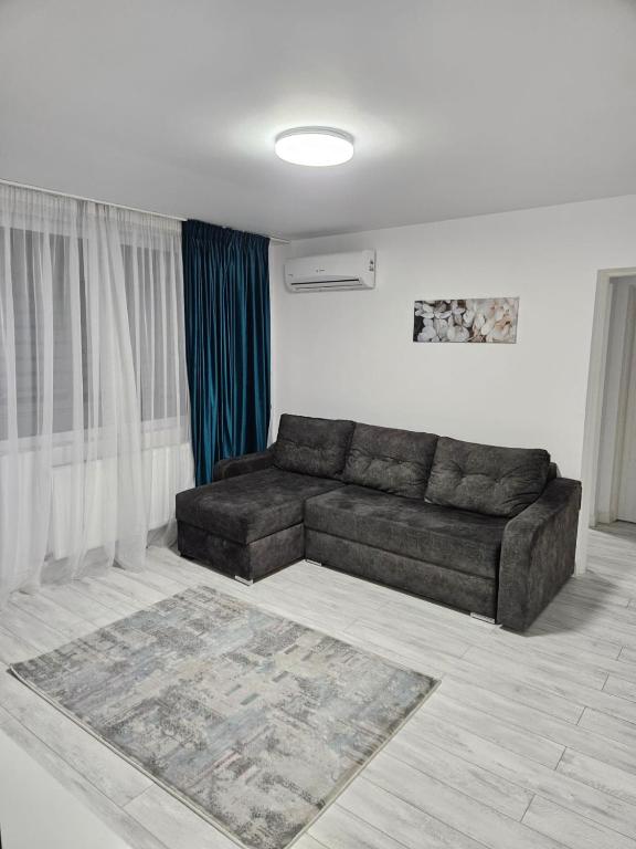 a living room with a brown couch in a room at Apartament 2 camere in Onești