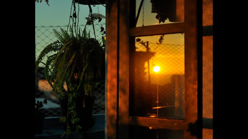 a window with a view of a sunset seen through it at Santo Antônio Além do Carmo - apartamento com varanda e vista pro mar, até 3 pessoas in Salvador