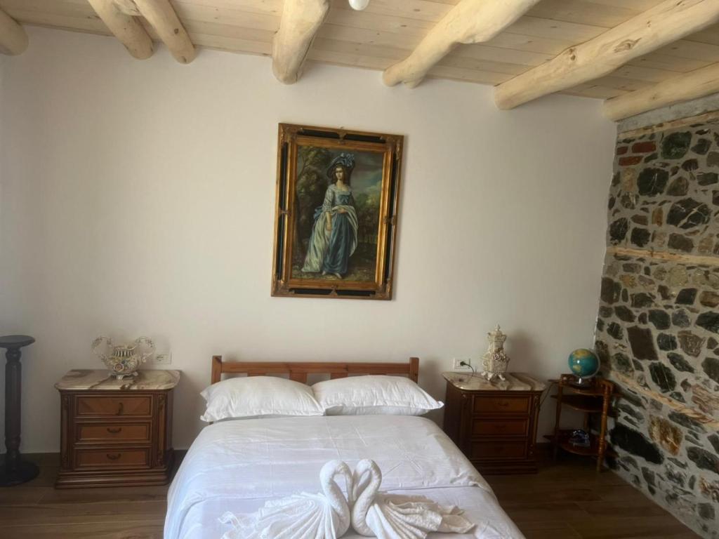 a bedroom with a bed and a painting on the wall at Bujtina Hakorja 1988 in Peshkopi