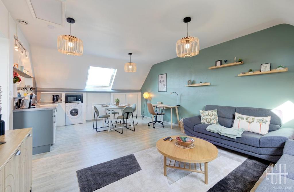 una sala de estar con un sofá y una mesa en Le Mirabeau - Gare à 100m - Wifi - Bureau - 2 V, en Saint-Pierre-des-Corps