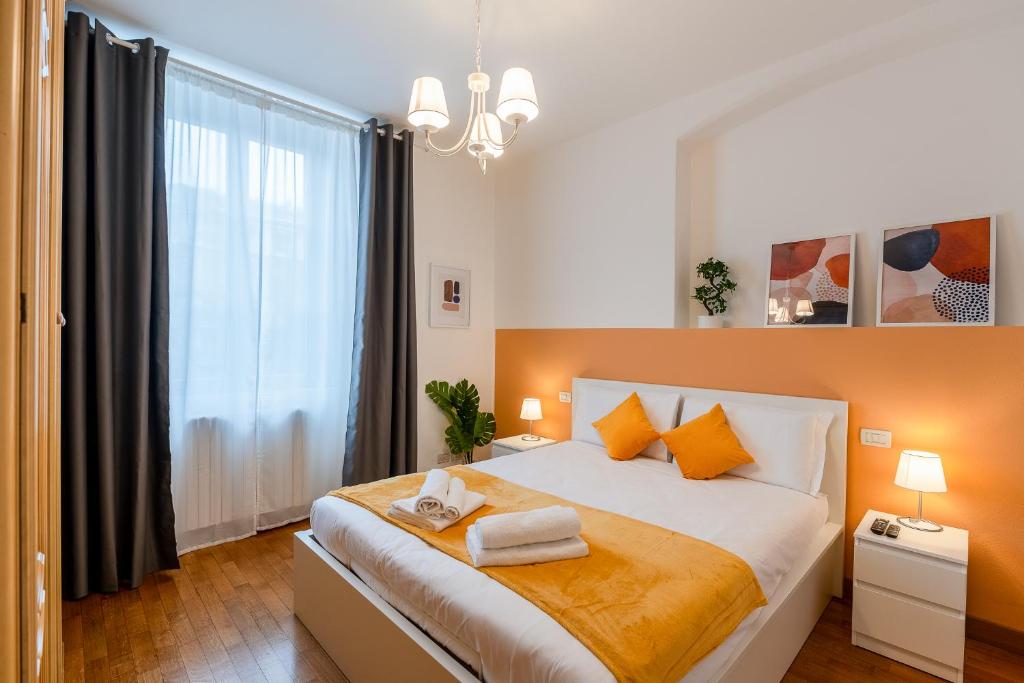 ミラノにある"Suite Elegance Brera"のベッドと大きな窓のある寝室